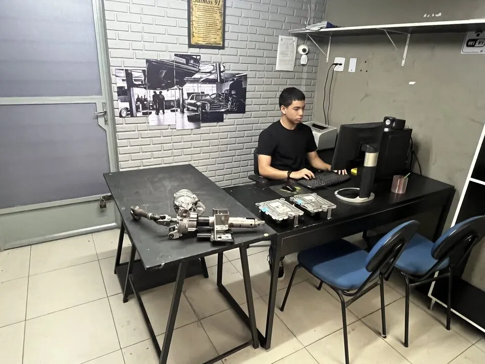 Funcionário trabalhando no computador em uma sala técnica